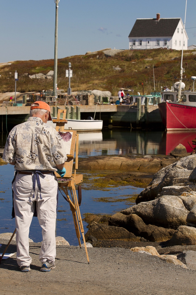 Artist painting boats in harbour               